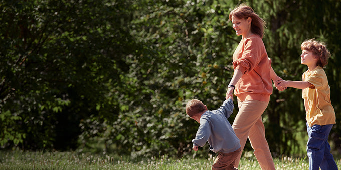 Woman walking with two children in a park